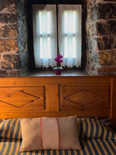 a bedroom with a bed with a dresser and two windows at Hotel Rural Los Texos in La Riera