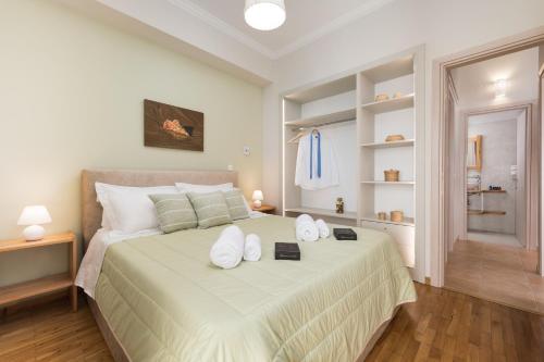 a bedroom with a large bed with white pillows at UniQApt in Corfu