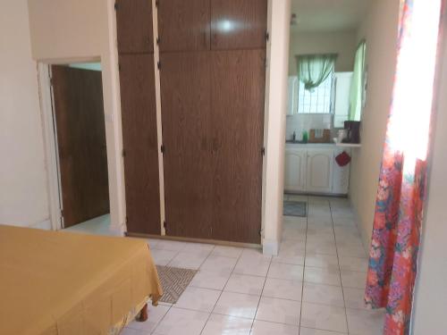 a living room with a door and a kitchen at Ocean View Apartments By-BLR in Bridgetown
