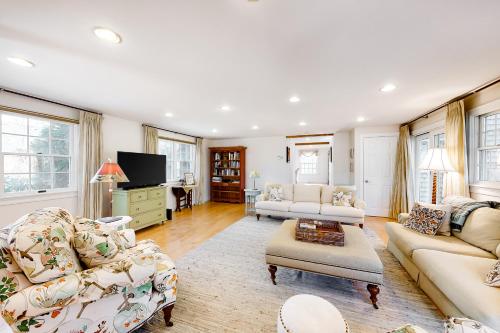 a living room with two couches and a tv at Pine Street Haven in Edgartown