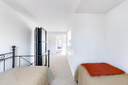 a white room with a bed and a hallway at Pine Street Haven in Edgartown