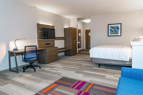 a hotel room with a bed and a desk with a computer at Holiday Inn Express & Suites - Columbus - Worthington by IHG in Columbus
