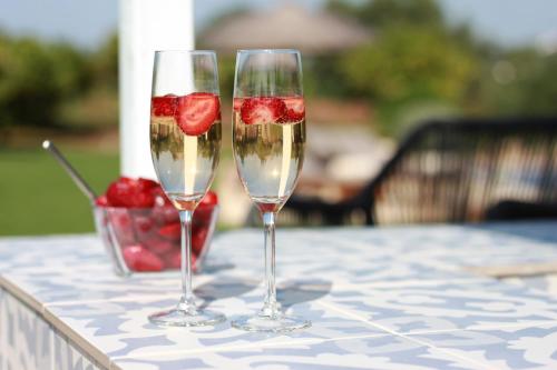two wine glasses with strawberries in them on a table at Quinta da Luz - A Luxury Boutique B&B in Silves