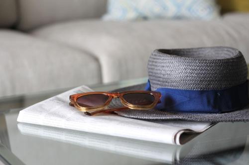 a pair of glasses and a hat on a glass table at Quinta da Luz - A Luxury Boutique B&B in Silves