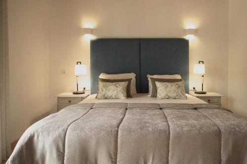 a bedroom with a large bed with two lamps at Quinta da Luz - A Luxury Boutique B&B in Silves