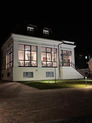 a white house with a lot of windows at night at Villa Ljiljana in Vinkovci