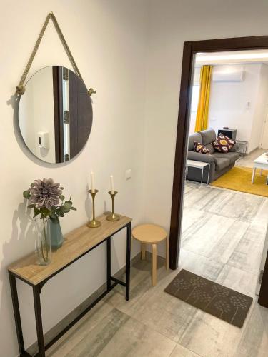 a living room with a table and a mirror at Apartamentos Cantarería, Azahar in Setenil