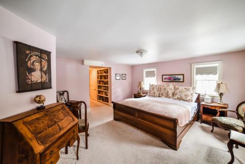 a bedroom with a large bed and a chair at Adair Country Inn & Restaurant in Bethlehem