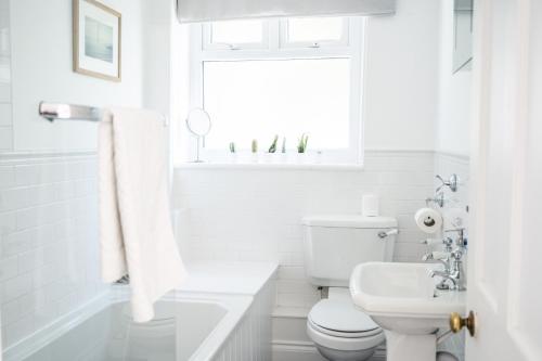 a white bathroom with a toilet and a sink at Flat 1 Teneriffe in Lyme Regis