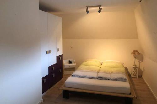 a bedroom with a bed with a light on it at Großzügiges Reetdachhaus an der Nordsee in Langenhorn