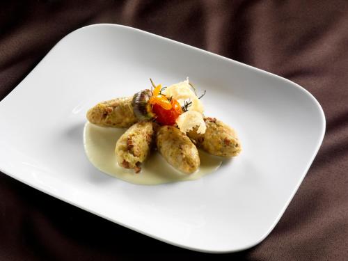 a white plate with some food on it at Hotel Garden in Moena
