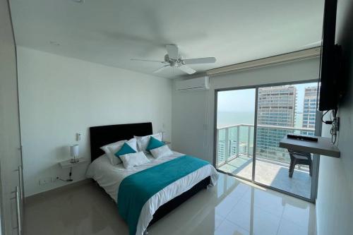 een slaapkamer met een bed en een balkon met uitzicht bij Infinitum Bocagrande-Piso 26-Apartamento Nuevo in Cartagena