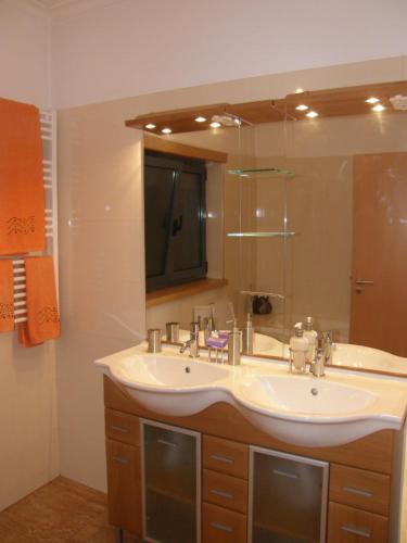 Un baño con lavabo y un espejo grande. en Casa de Água levada, en Picarouba