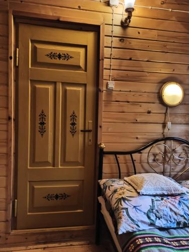 a door in a room with a bed next to it at Agroturystyka Bora Zdrój in Narewka