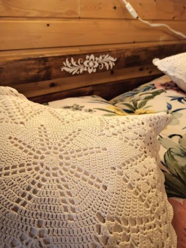 a crocheted pillow sitting on a bed at Agroturystyka Bora Zdrój in Narewka