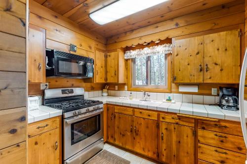 a kitchen with wooden cabinets and a stove at Williams Cabin in Shaver Lake