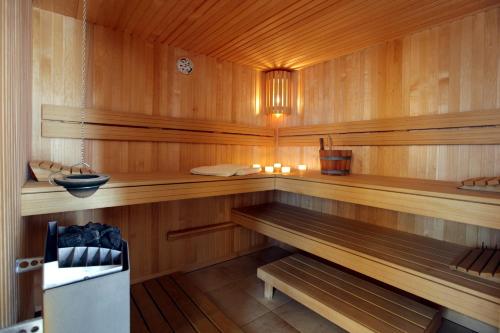 a sauna with wooden walls and benches and candles at Ambassador Hotel in De Panne