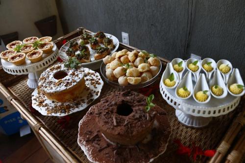 una tavola ricoperta con diversi tipi di torte e prodotti da forno di Pousada Recanto a Fernando de Noronha