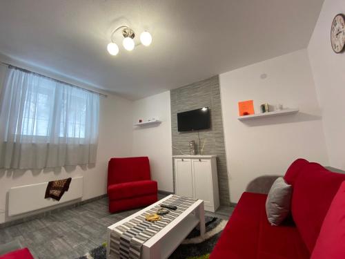 - un salon avec un canapé et un fauteuil rouge dans l'établissement Bele Staze Kopaonik s, à Brzeće