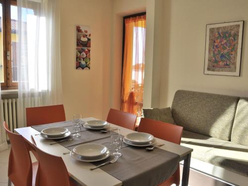 a dining room table and chairs with a table and a couch at Belvilla by OYO Argentina Cinque in Lazise