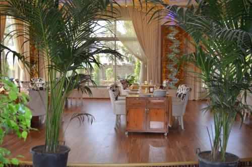 a room with a table and chairs and plants at Hotel Dawa in As Sulaymānīyah