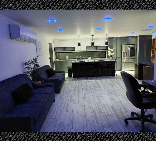 a living room with a blue couch and a kitchen at The Villas Beach House in Rosarito