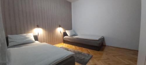 a small room with two beds and two lights at Apartman EXCLUZIV in Prijedor