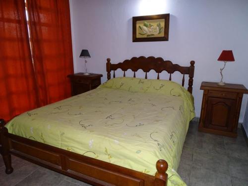 a bed in a bedroom with two night stands and two lamps at LAS MARIAS - CHAJARI in Chajarí