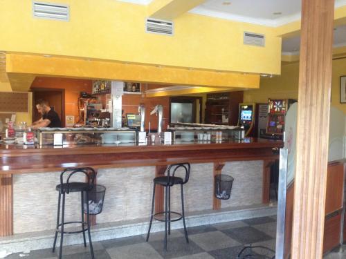 un bar in un ristorante con due sgabelli da bar di Hostal González a Guadarrama