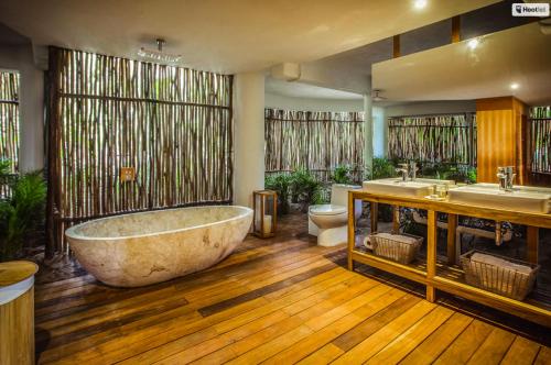 uma grande casa de banho com uma grande banheira e 2 lavatórios em All inclusive beachfront villa in Sian kaan em Tulum