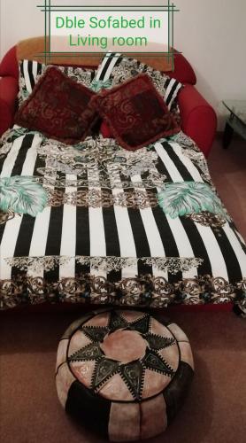 a bed with a black and white quilt on it at The Loft in Foxford in Foxford