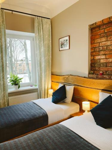 a bedroom with two beds and a window at Hotel Benevilla in Alūksne