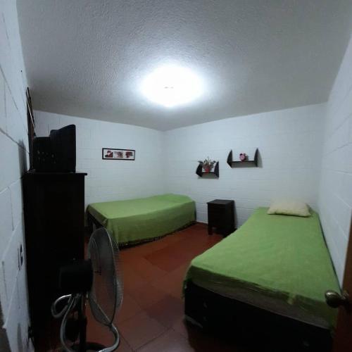 a room with two beds and a flat screen tv at Apartasol El Encanto in San Jerónimo