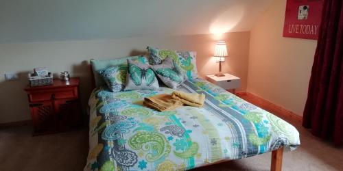 um quarto com uma cama com um edredão colorido em The Loft in Foxford em Foxford