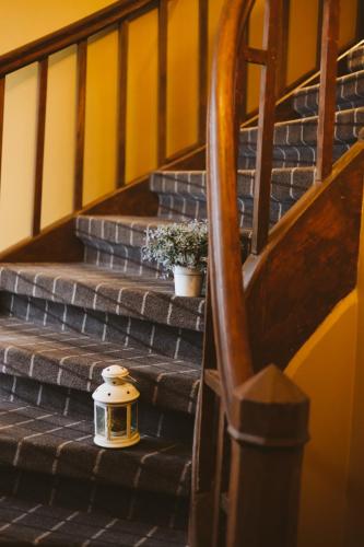 a lantern sitting on the stairs of a house at Hotel Benevilla in Alūksne