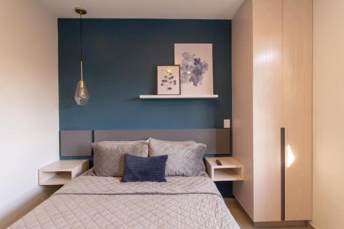 Lofts Santa Fe في غواذالاخارا: غرفة نوم بسرير مع جدار ازرق