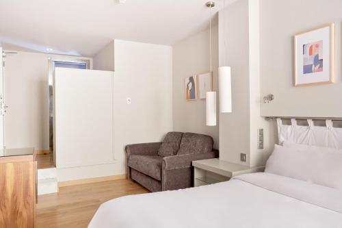 1 dormitorio con 1 cama y 1 silla en Vasanta powered by Sonder, en Barcelona