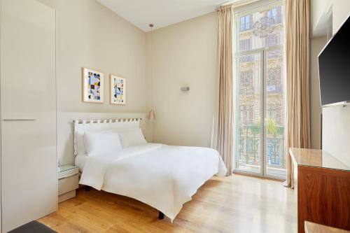 バルセロナにあるVasanta powered by Sonderの白いベッドルーム(ベッド1台、大きな窓付)