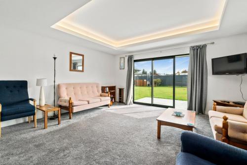 un soggiorno con mobili e una grande finestra di Erskine Place - Lake Hawea Holiday Home a Lake Hāwea