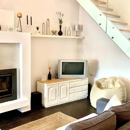 a living room with a tv on a white entertainment center at Casa Milheiras in Almeirim