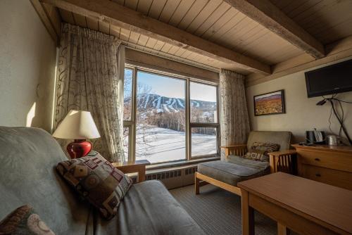 a living room with a couch and a window at Sugarloaf Inn in Carrabassett