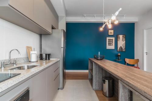 a kitchen with a counter and a blue wall at Charlie One Eleven Vila Olímpia in Sao Paulo