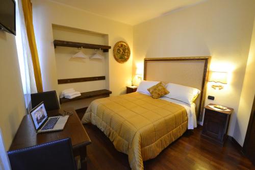 a hotel room with a bed and a desk with a laptop at Case Brizi Assisi in Assisi