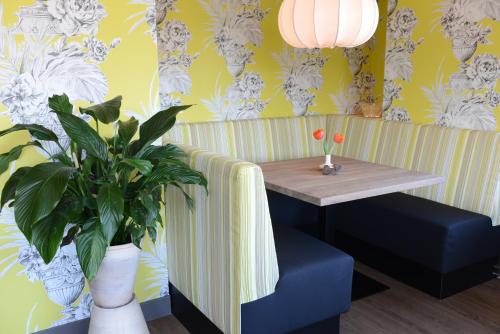a room with a table and a potted plant at Hotel Op Diek in Den Hoorn