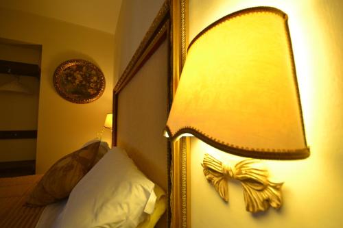a bedroom with a bed with a lamp on the wall at Case Brizi Assisi in Assisi