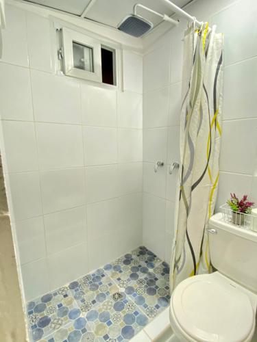 a bathroom with a shower and a toilet at Hotel Casa Tenango in Cobán