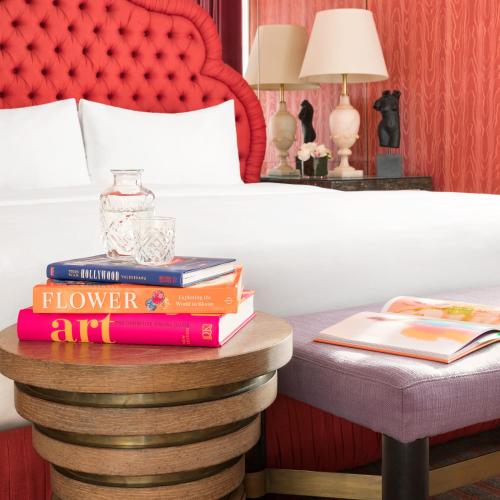 a pile of books on a table next to a bed at Maison 140 Beverly Hills in Los Angeles