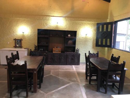 a dining room with two wooden tables and chairs at Hotel Casa Vieja in La Ceiba