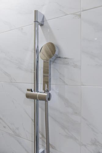 a shower head in a bathroom with white tiles at Hej Taipei in Taipei