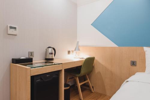 a room with a desk with a coffee maker and a bed at Hej Taipei in Taipei